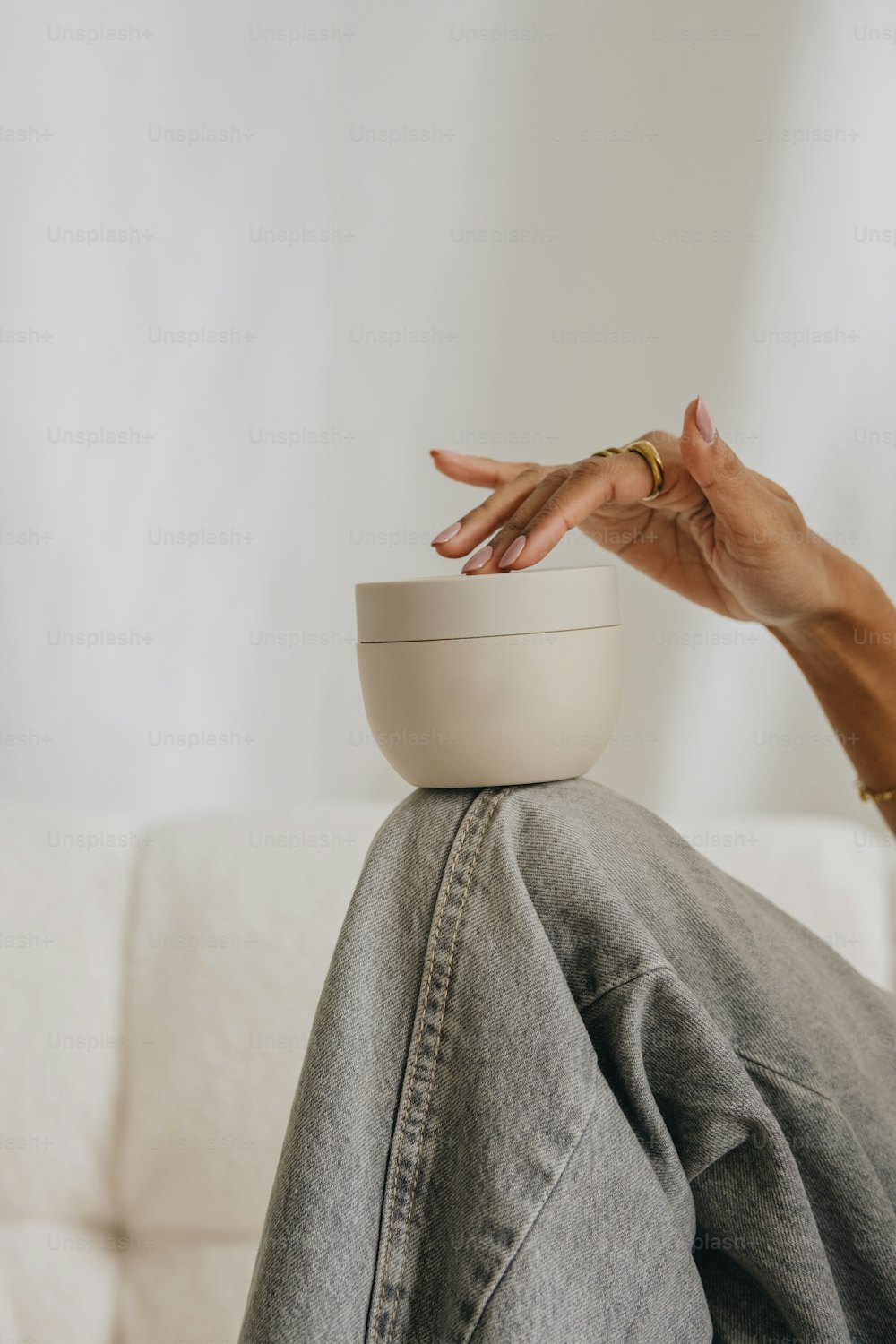 a person sitting on a couch with their hand on a bowl