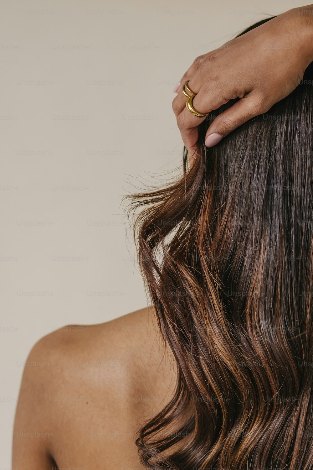 eine Frau mit langen braunen Haaren und einem goldenen Ring