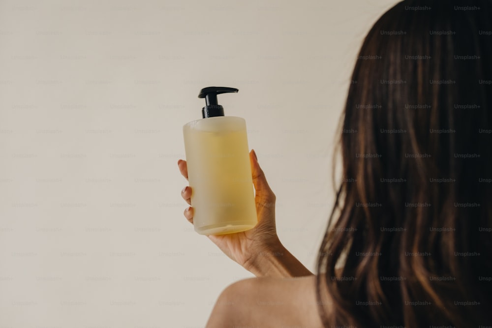 una mujer sosteniendo un dispensador de jabón en la mano