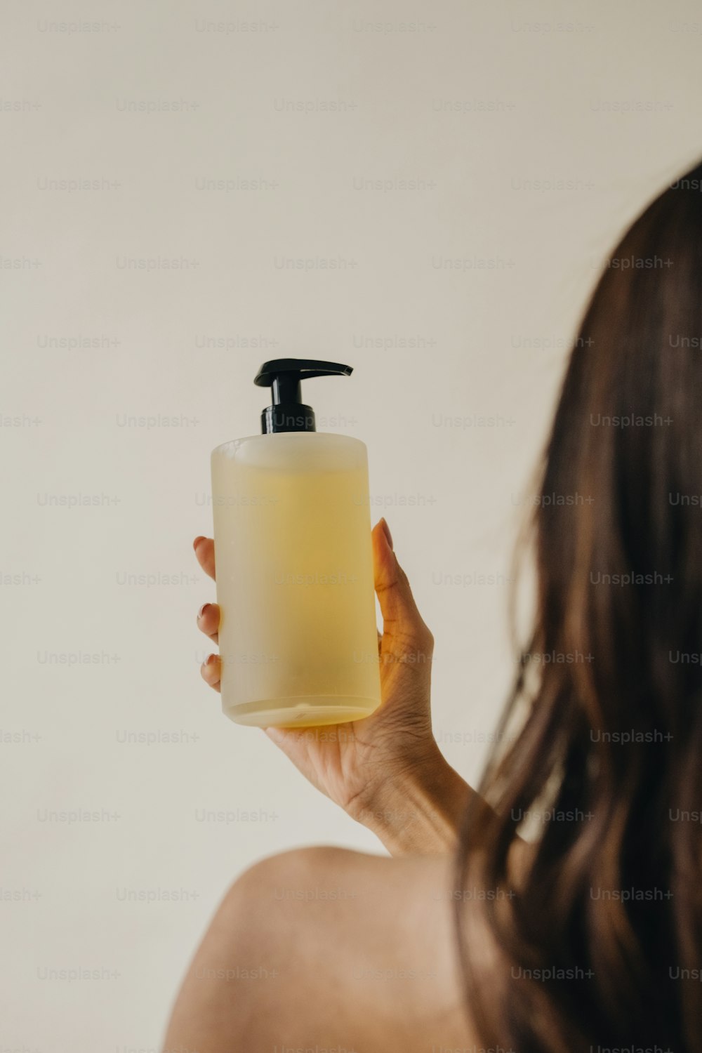 une femme tenant un distributeur de savon dans sa main