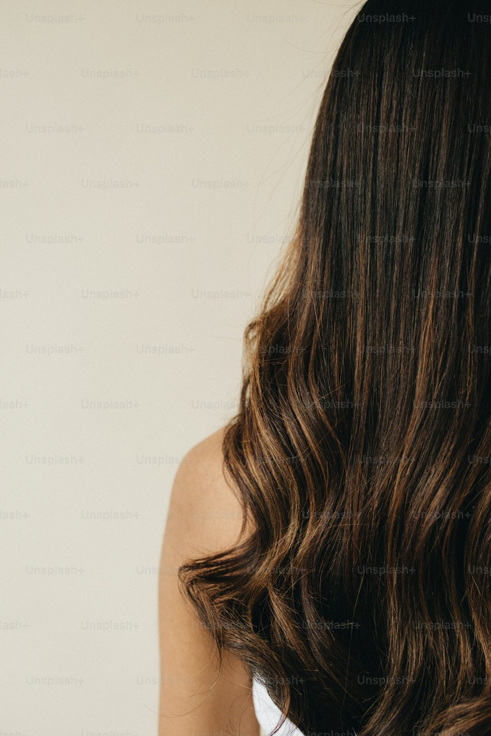 a woman is brushing her long brown hair