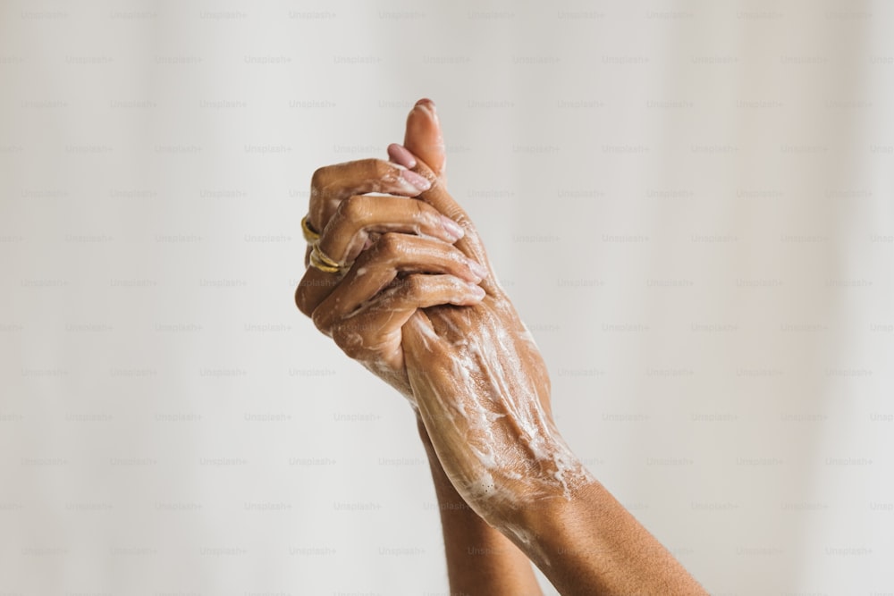 Die Hände einer Frau sind mit Seife bedeckt