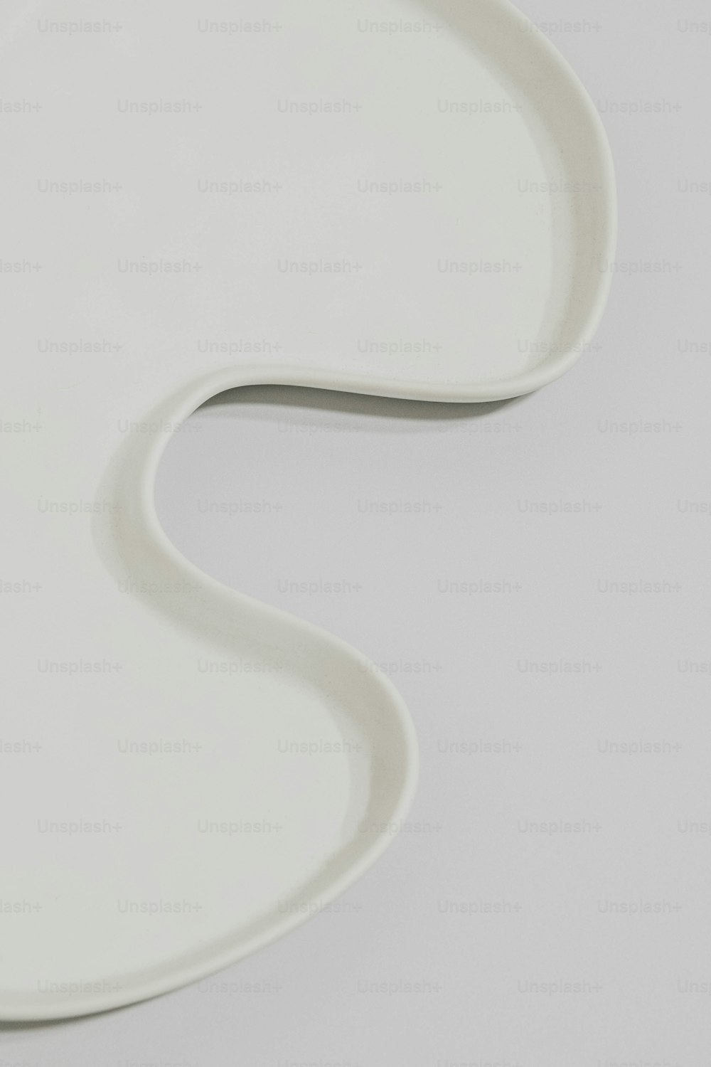 a white plate with a curved design on it