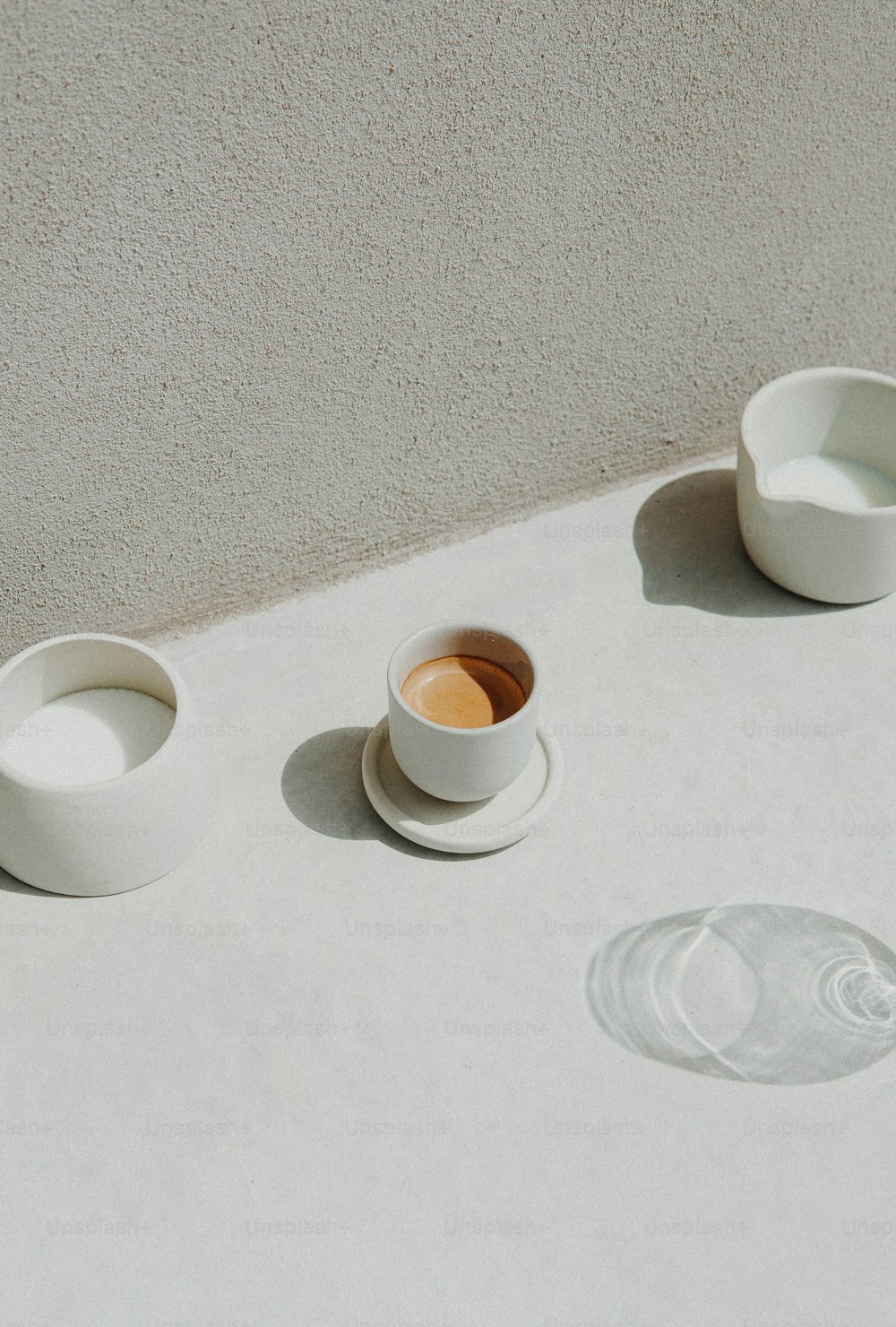 a table topped with white bowls and cups