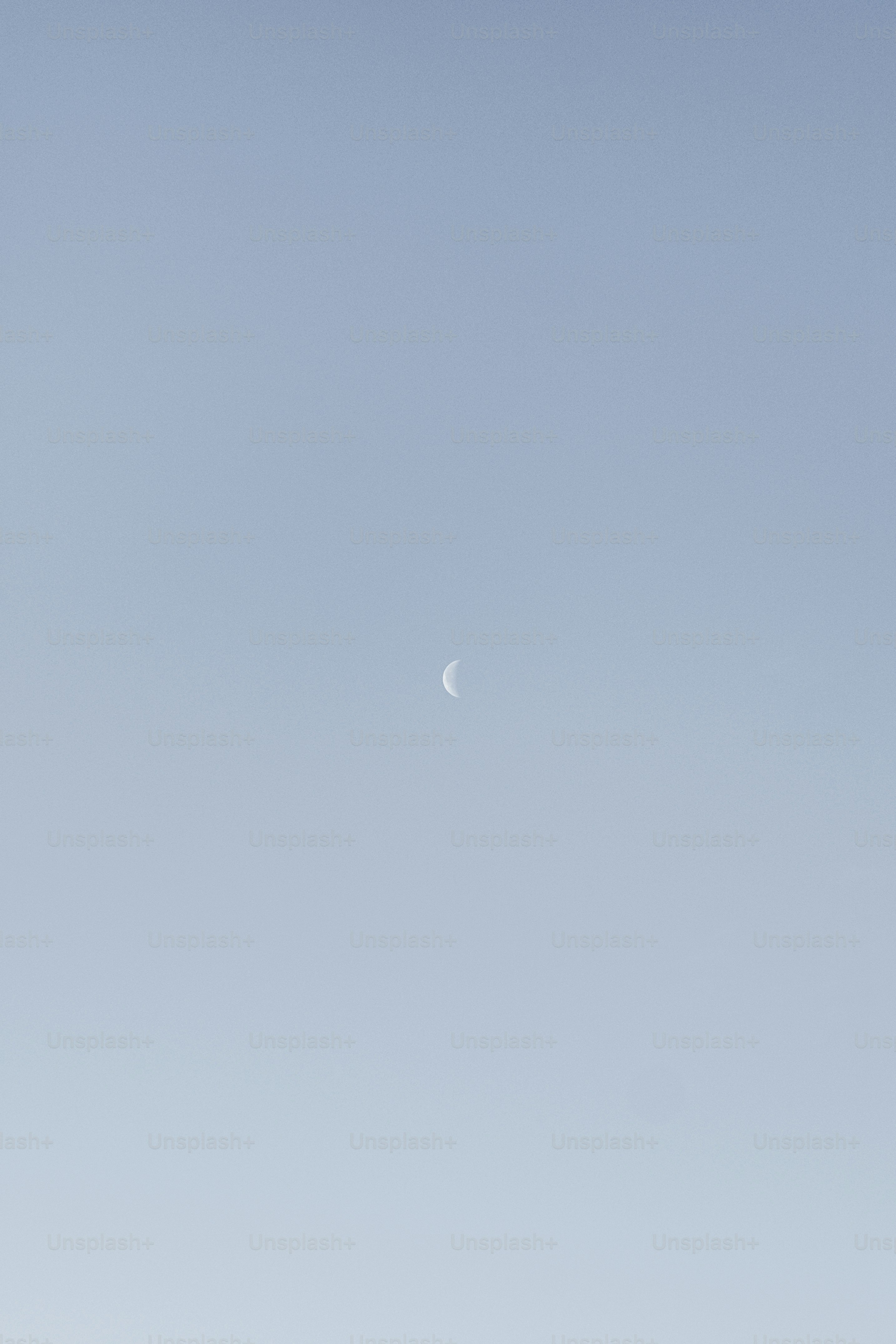 um avião voando no céu com uma meia lua à distância