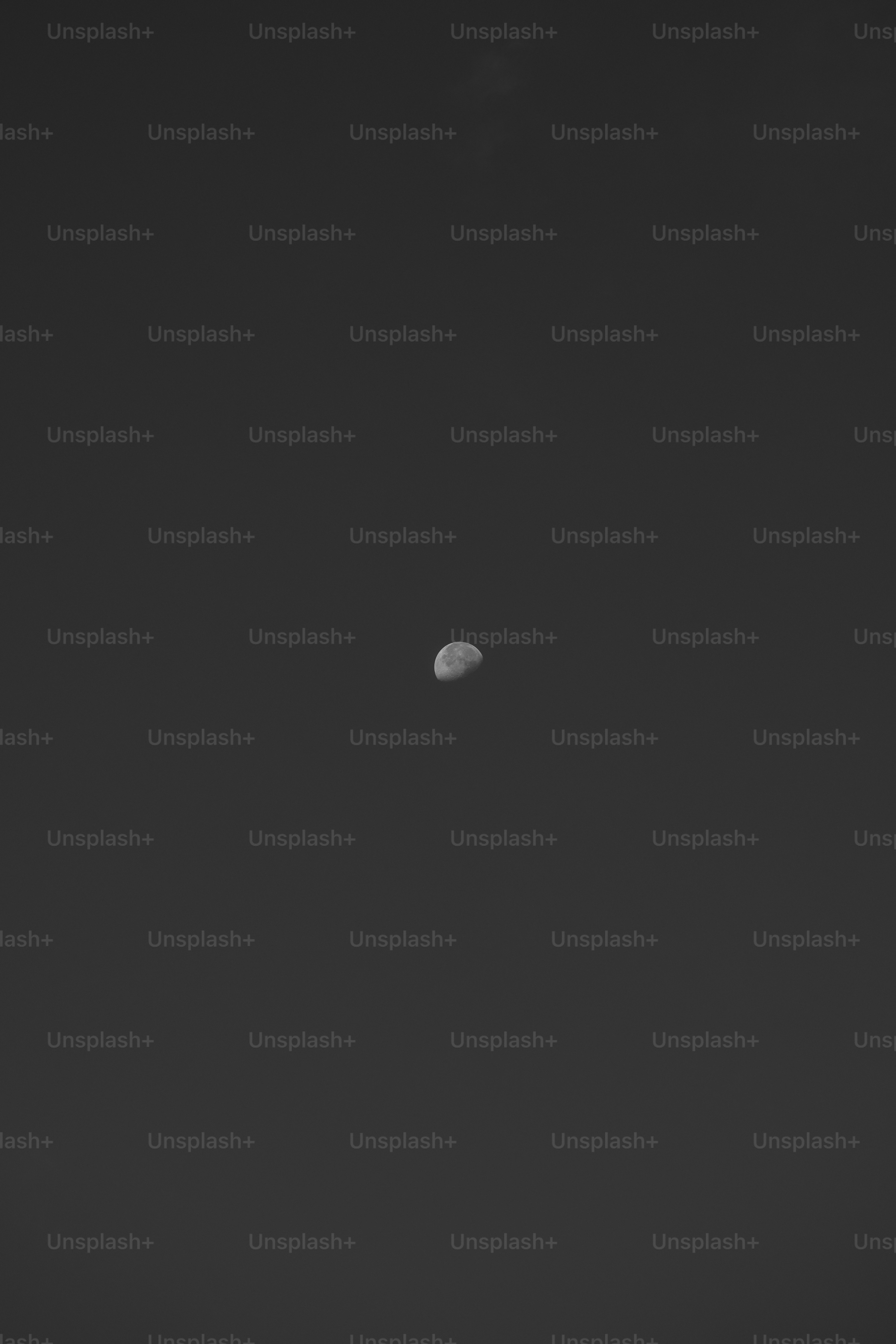 a black and white photo of a moon in the sky