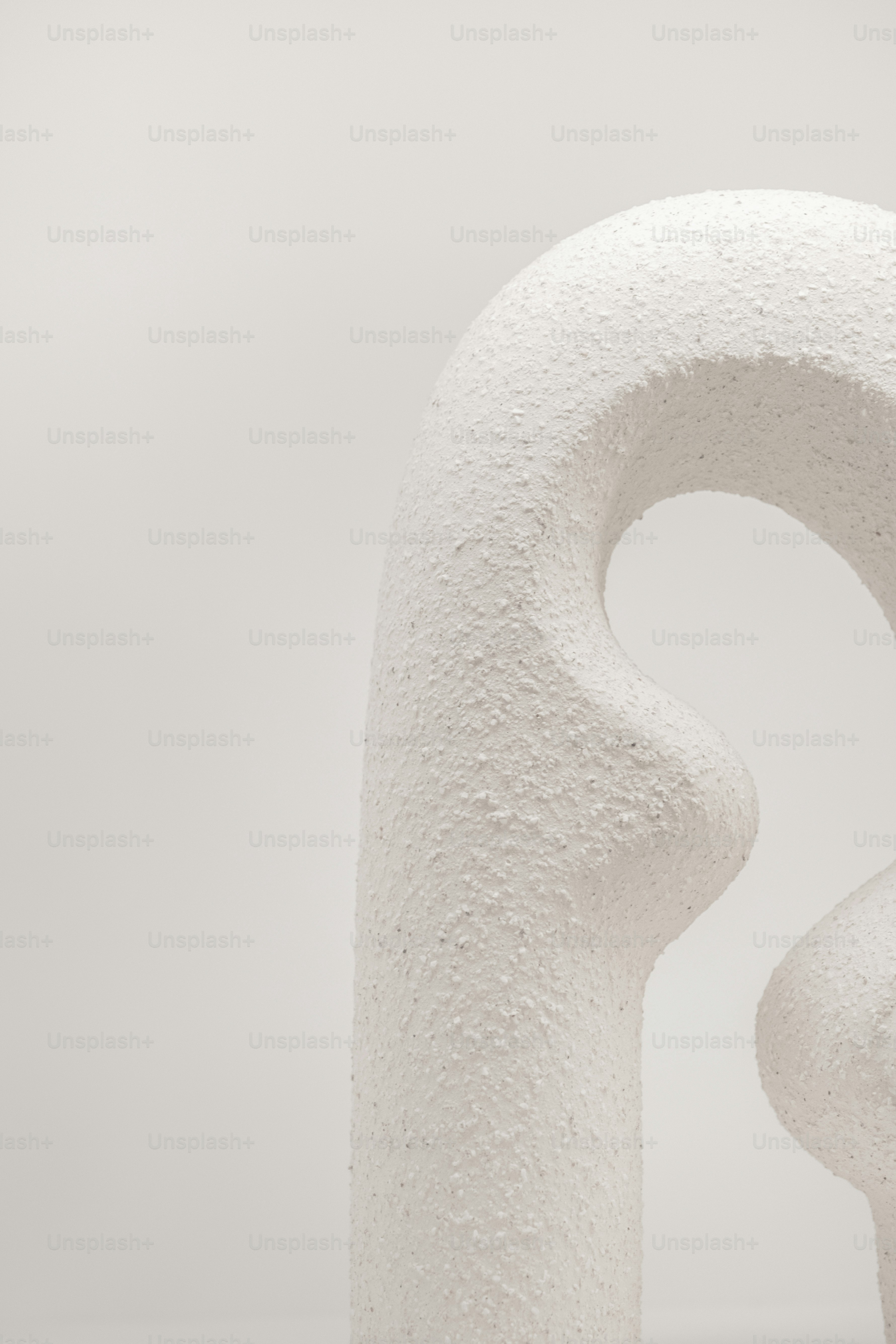 a white sculpture with a curved design on it