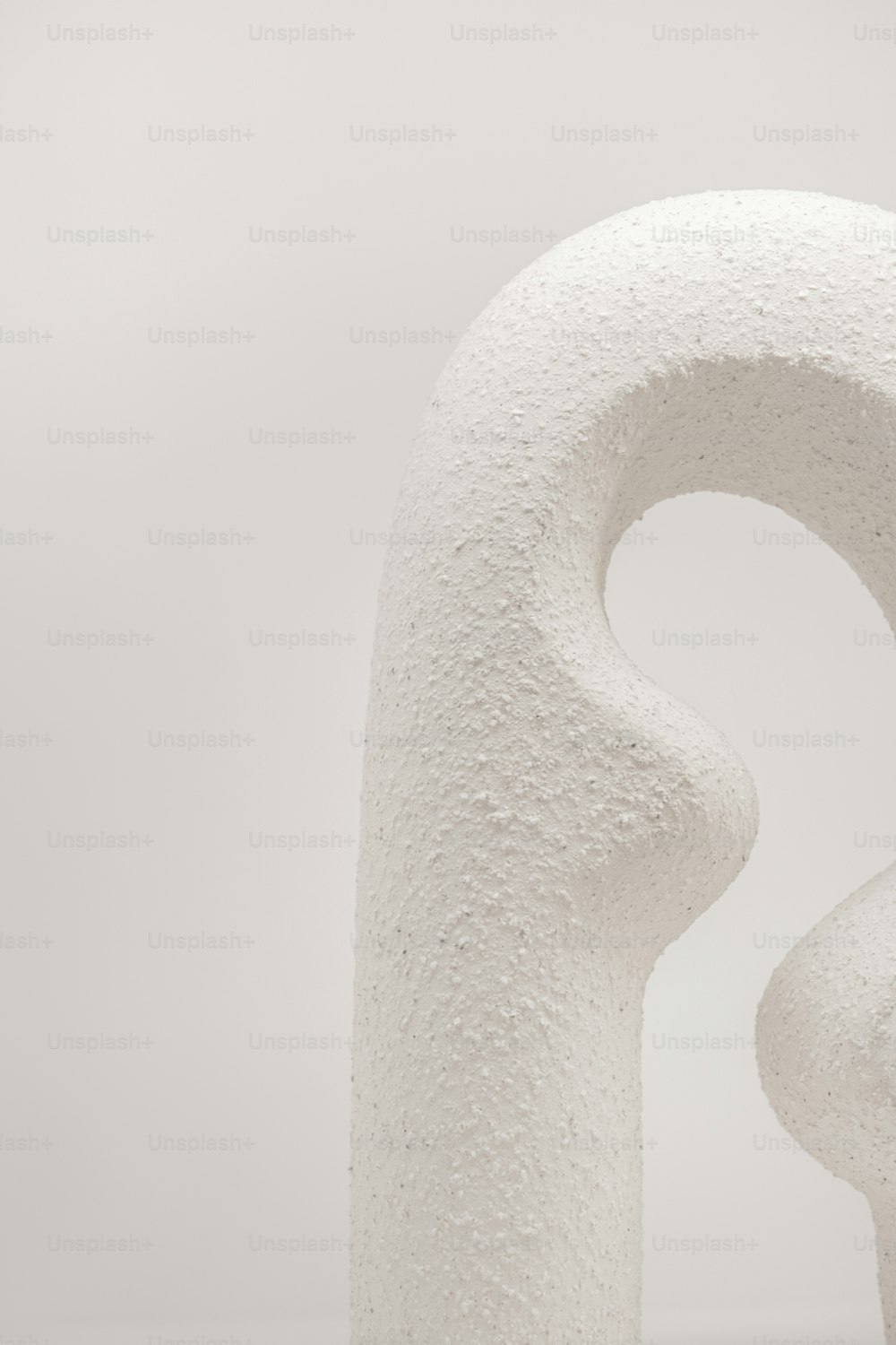 a white sculpture with a curved design on it