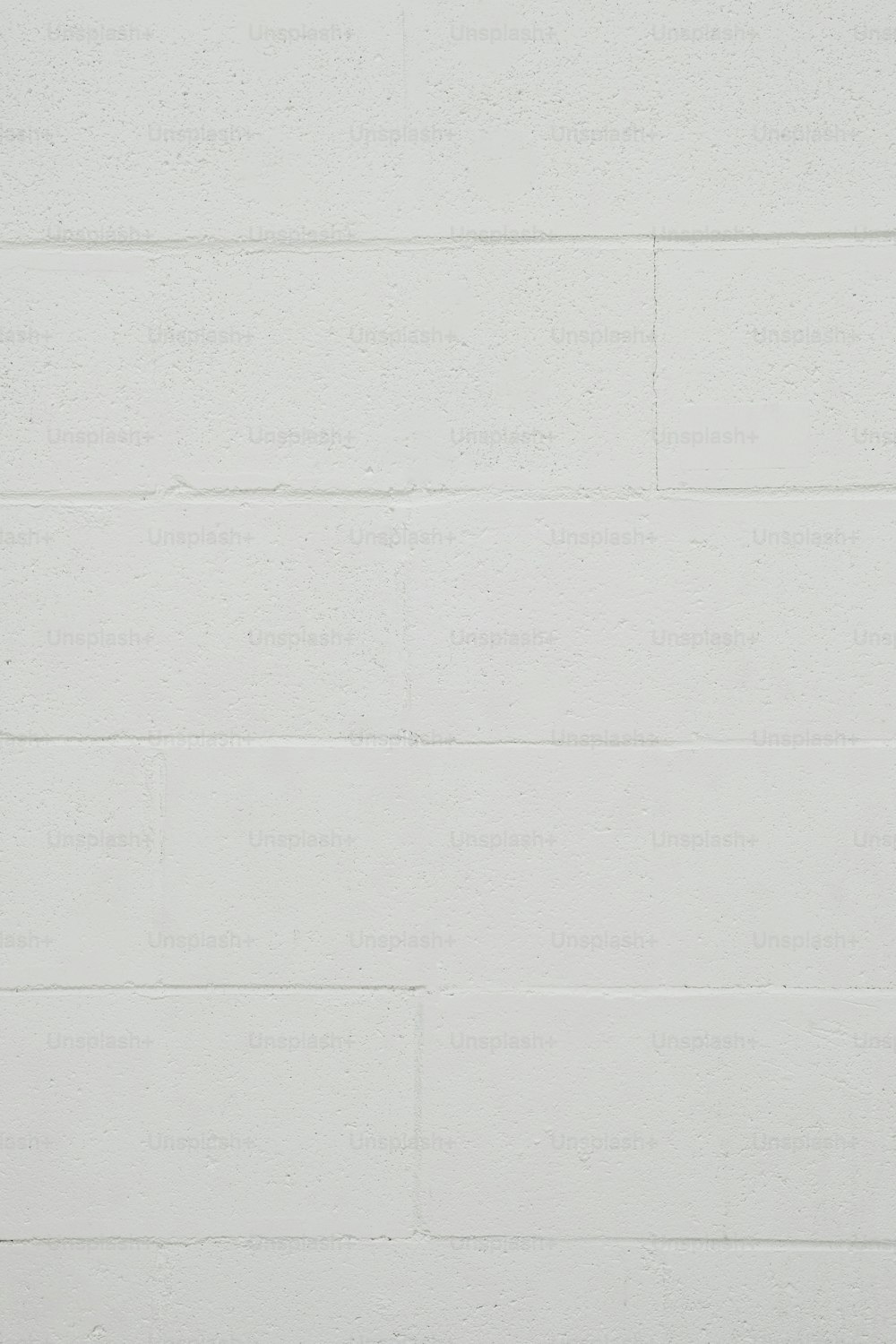 uma parede de tijolos brancos com um relógio preto e branco