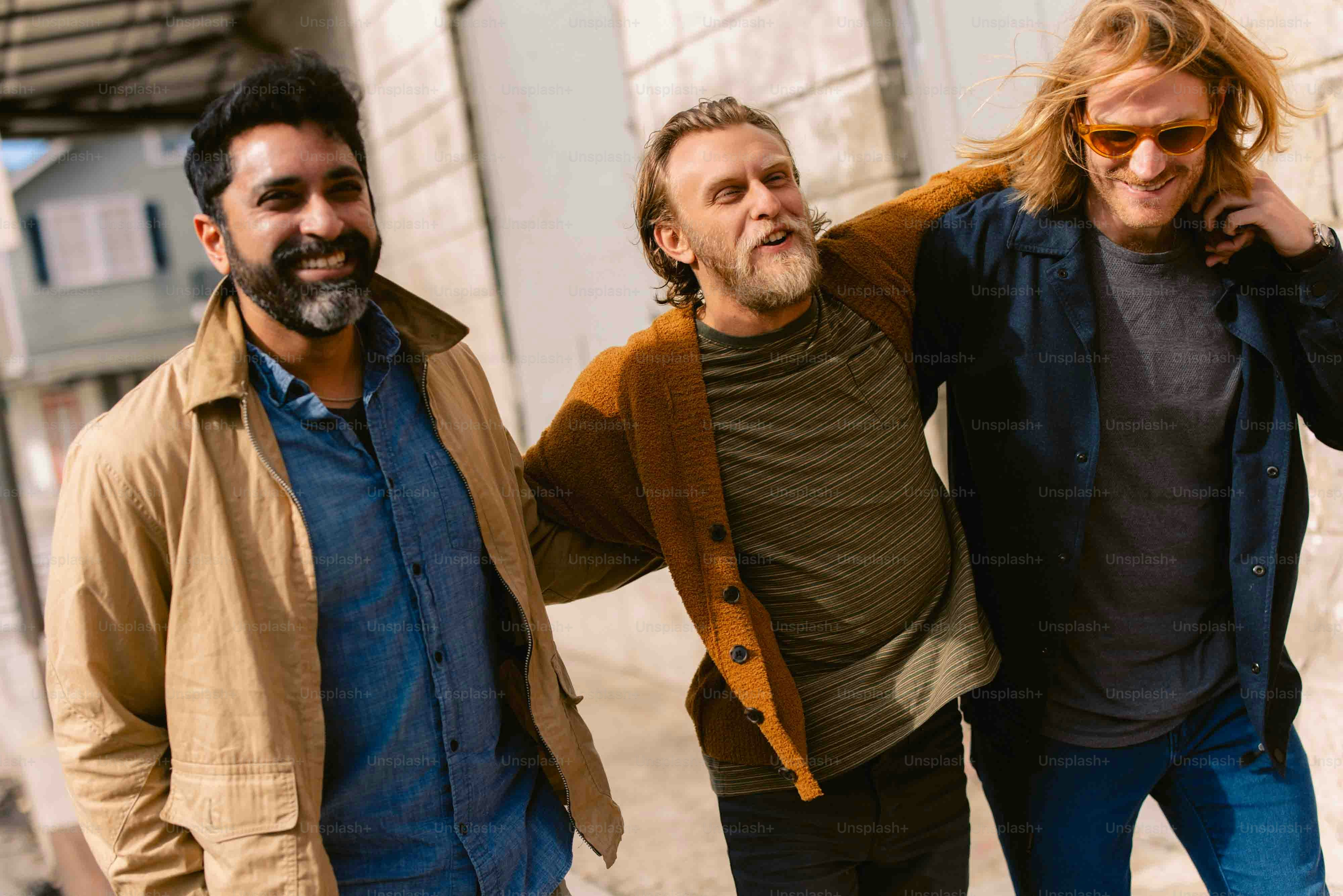A group of three men standing next to each other photo – Friends Image ...