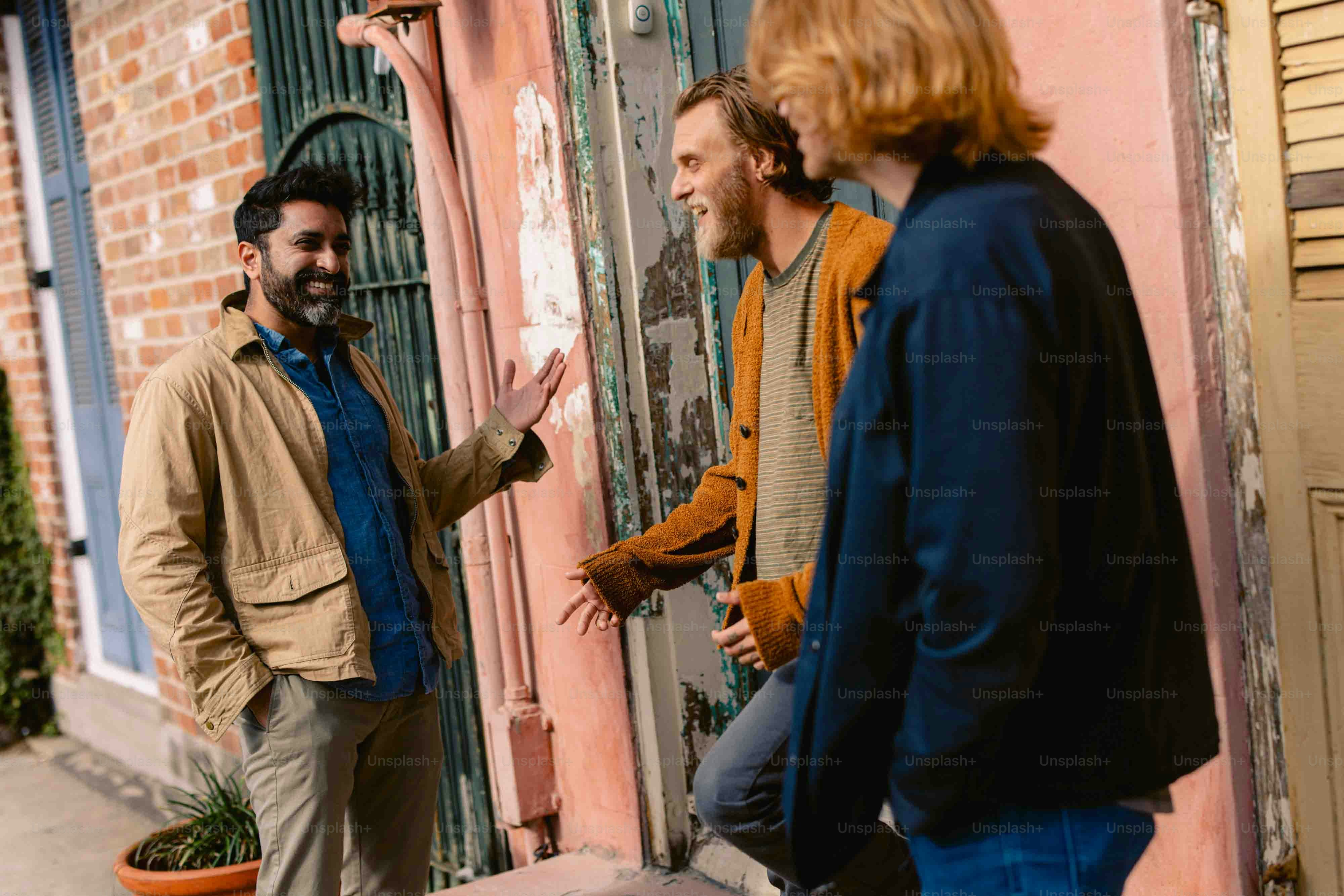 three men standing outside of a building talking to each other