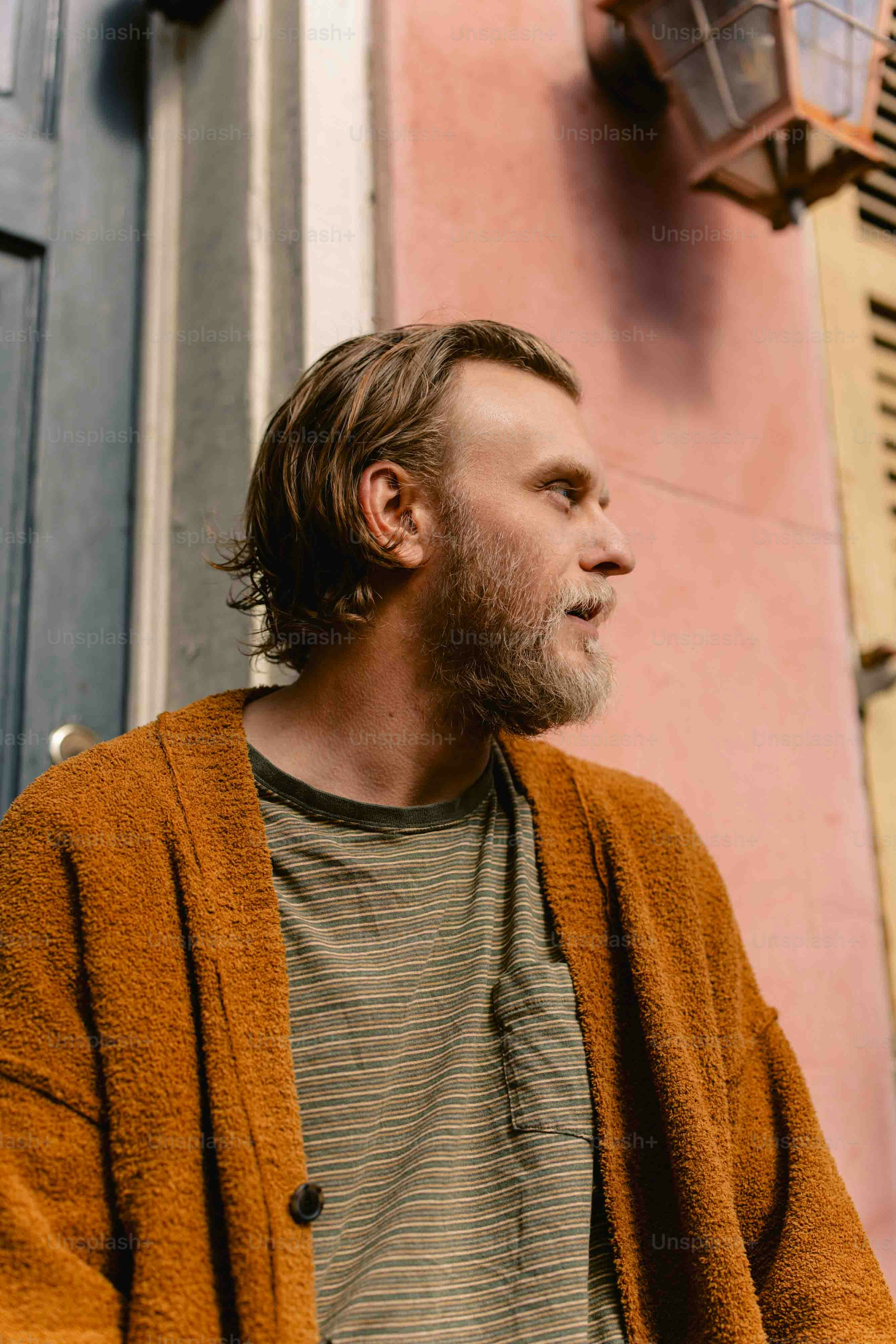 a man with a beard standing in front of a building