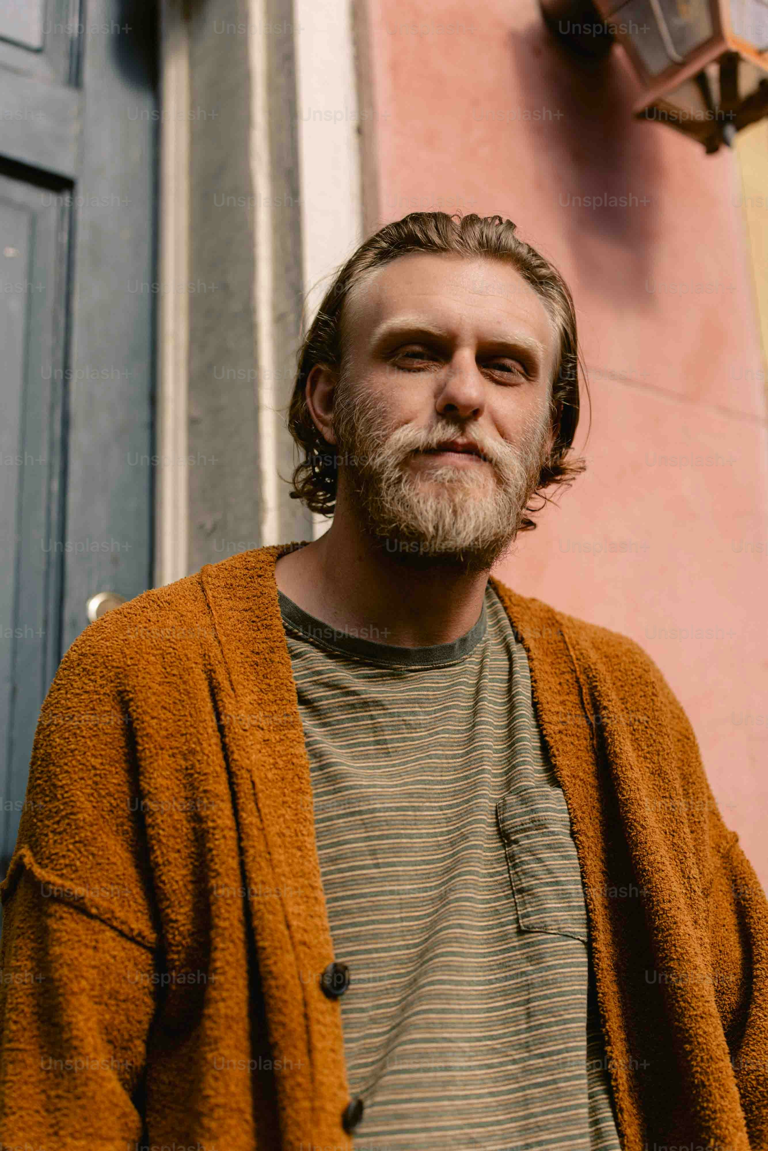 a man with a beard standing in front of a building