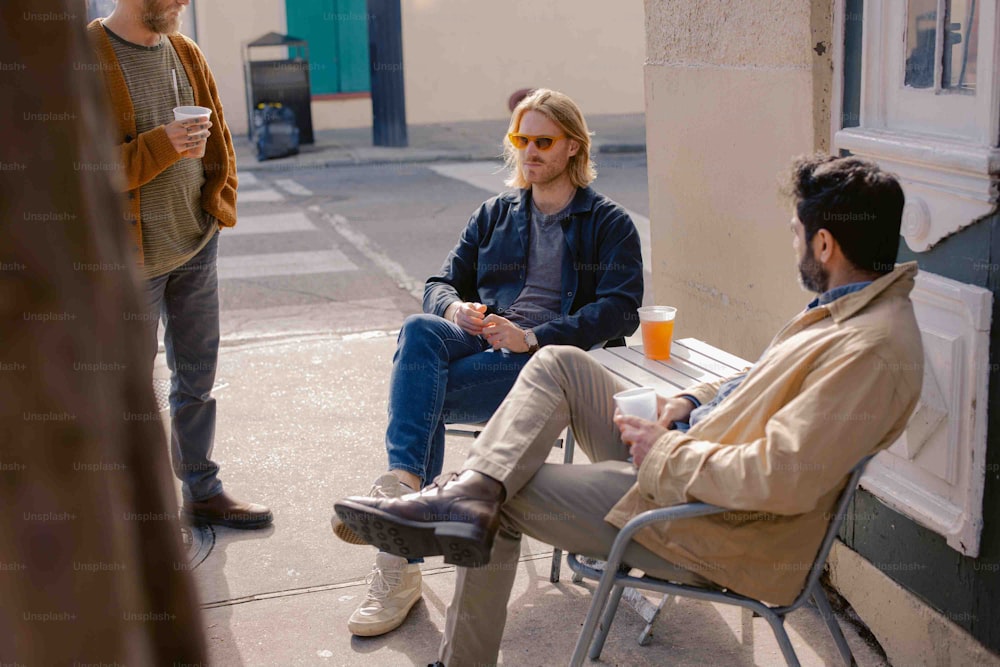 a man sitting on a bench next to another man