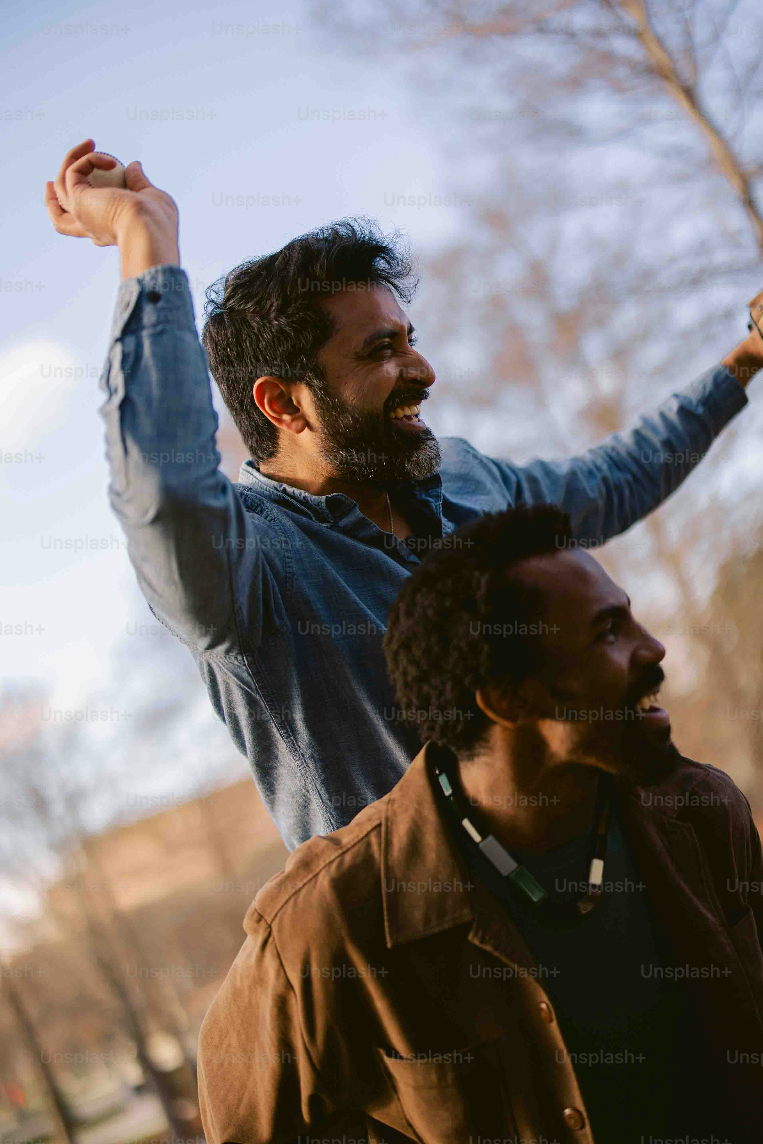 two men standing next to each other in a park