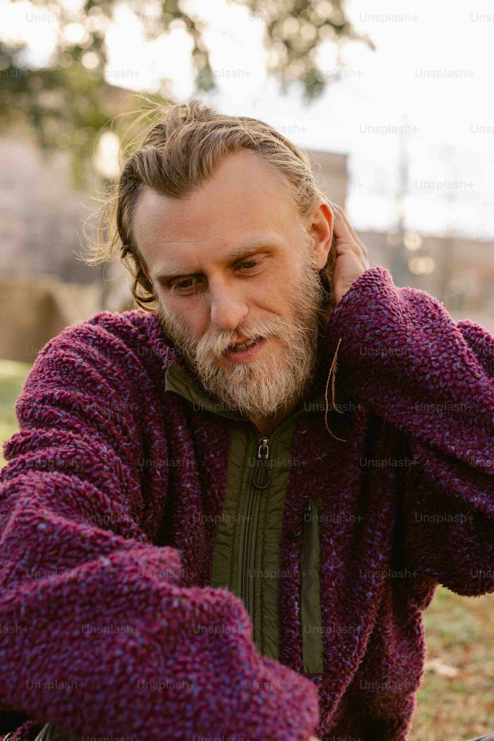 a man with a beard wearing a purple sweater