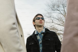un homme portant des lunettes de soleil debout à côté d’un autre homme