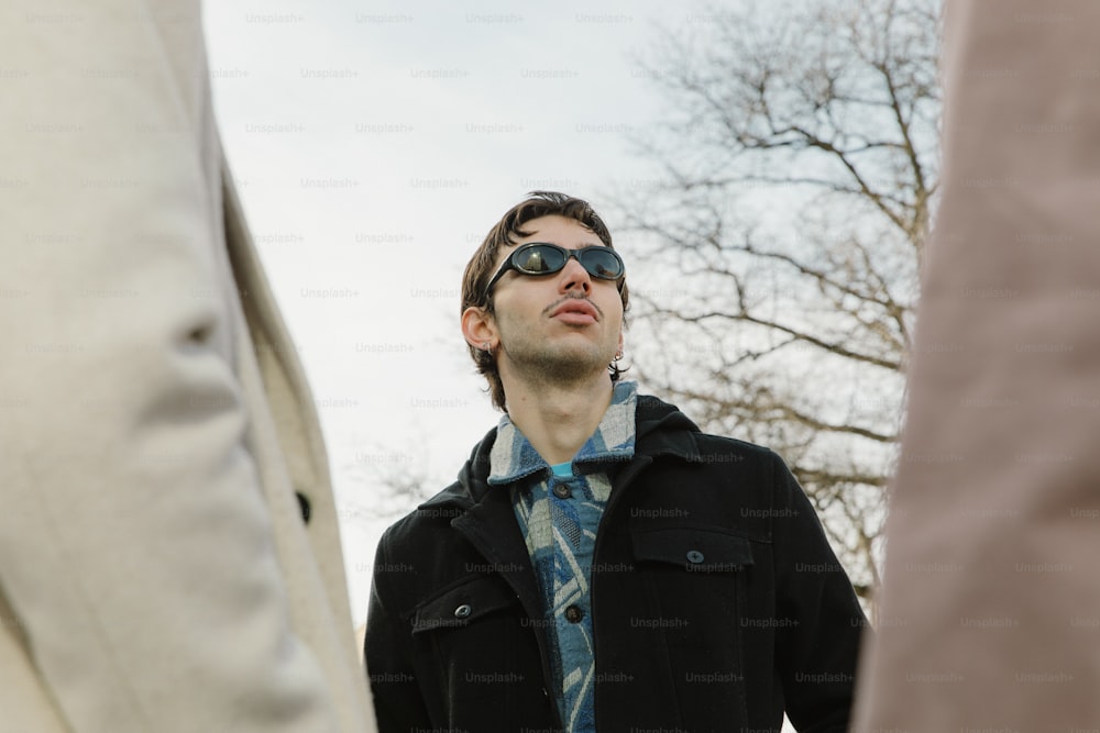 a man wearing sunglasses standing next to another man