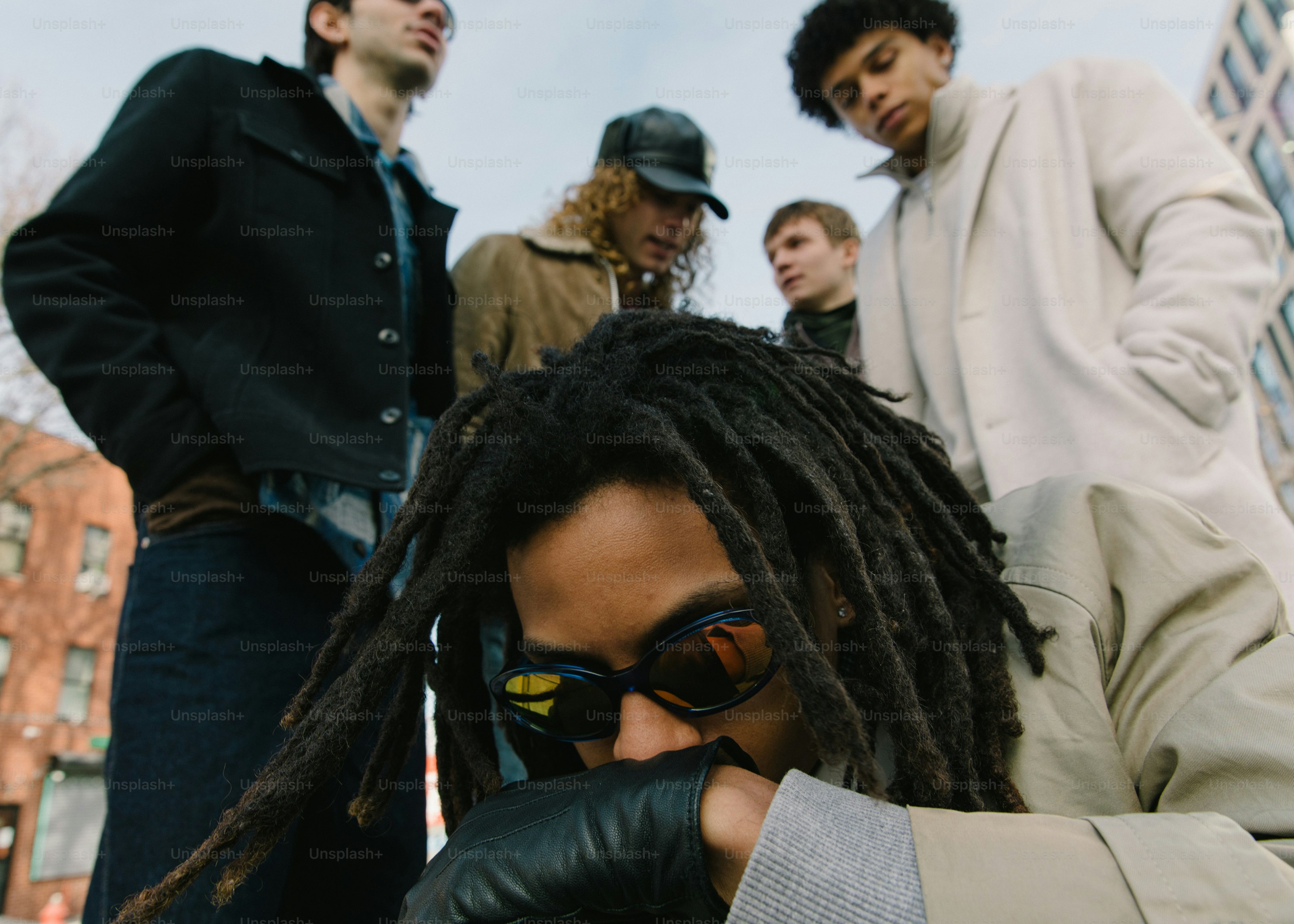 um homem com dreadlocks usando uma jaqueta e luvas
