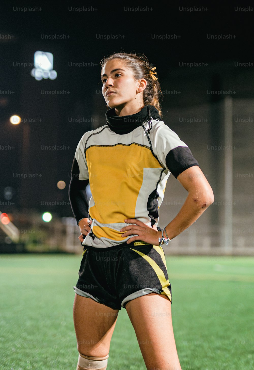 a female soccer player is standing on the field