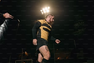 a man in a yellow and black uniform kicking a soccer ball
