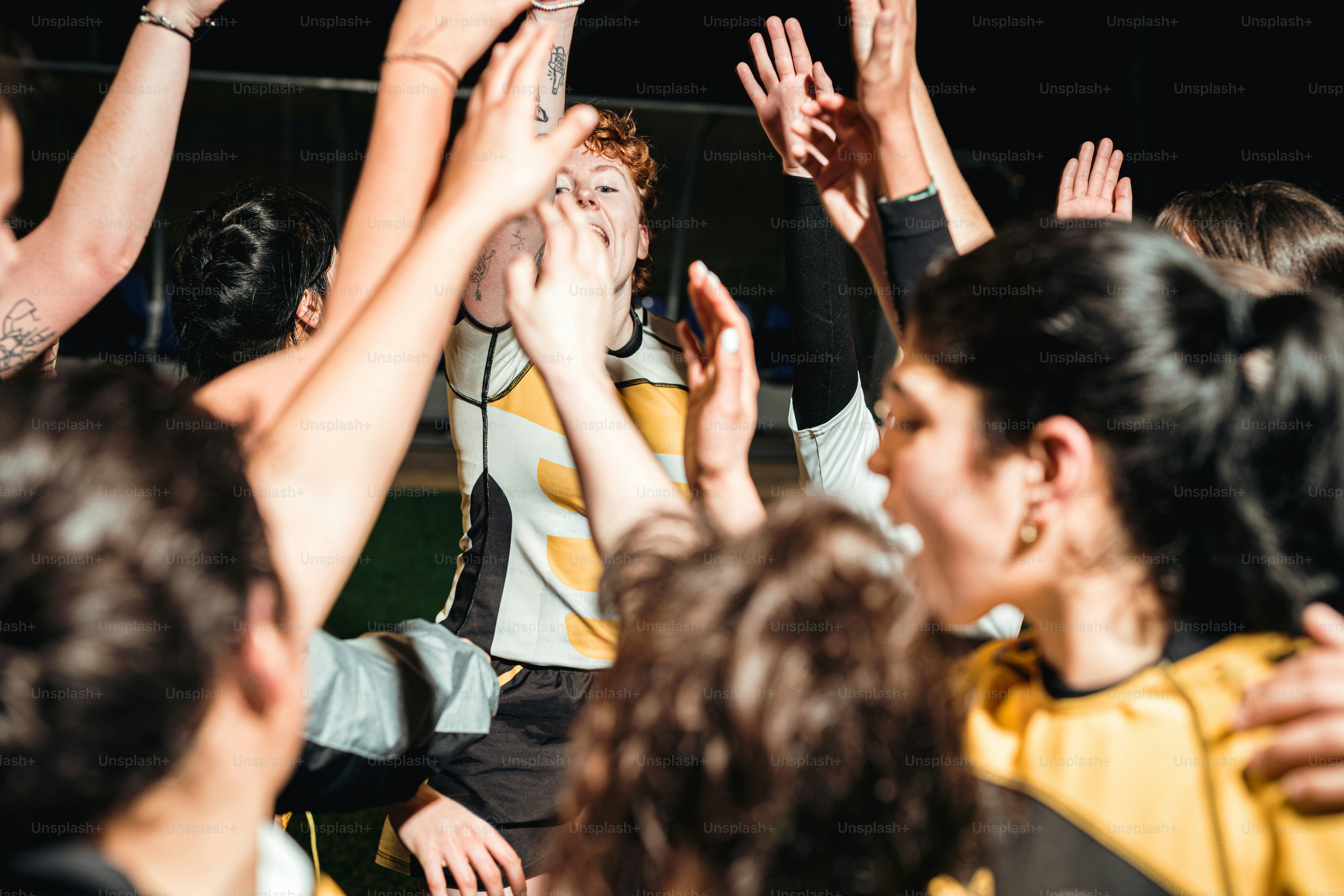 a group of people standing around each other with their hands in the air