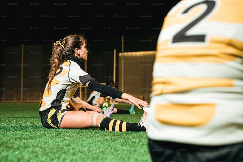 a female soccer player sitting on the ground