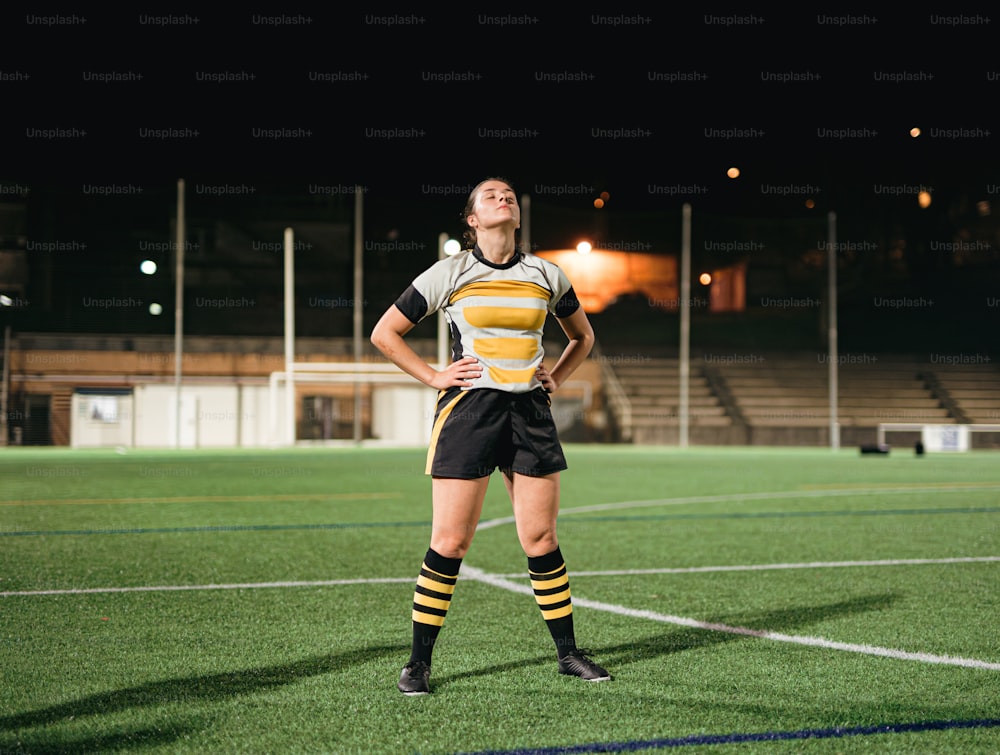 a female soccer player is standing on the field