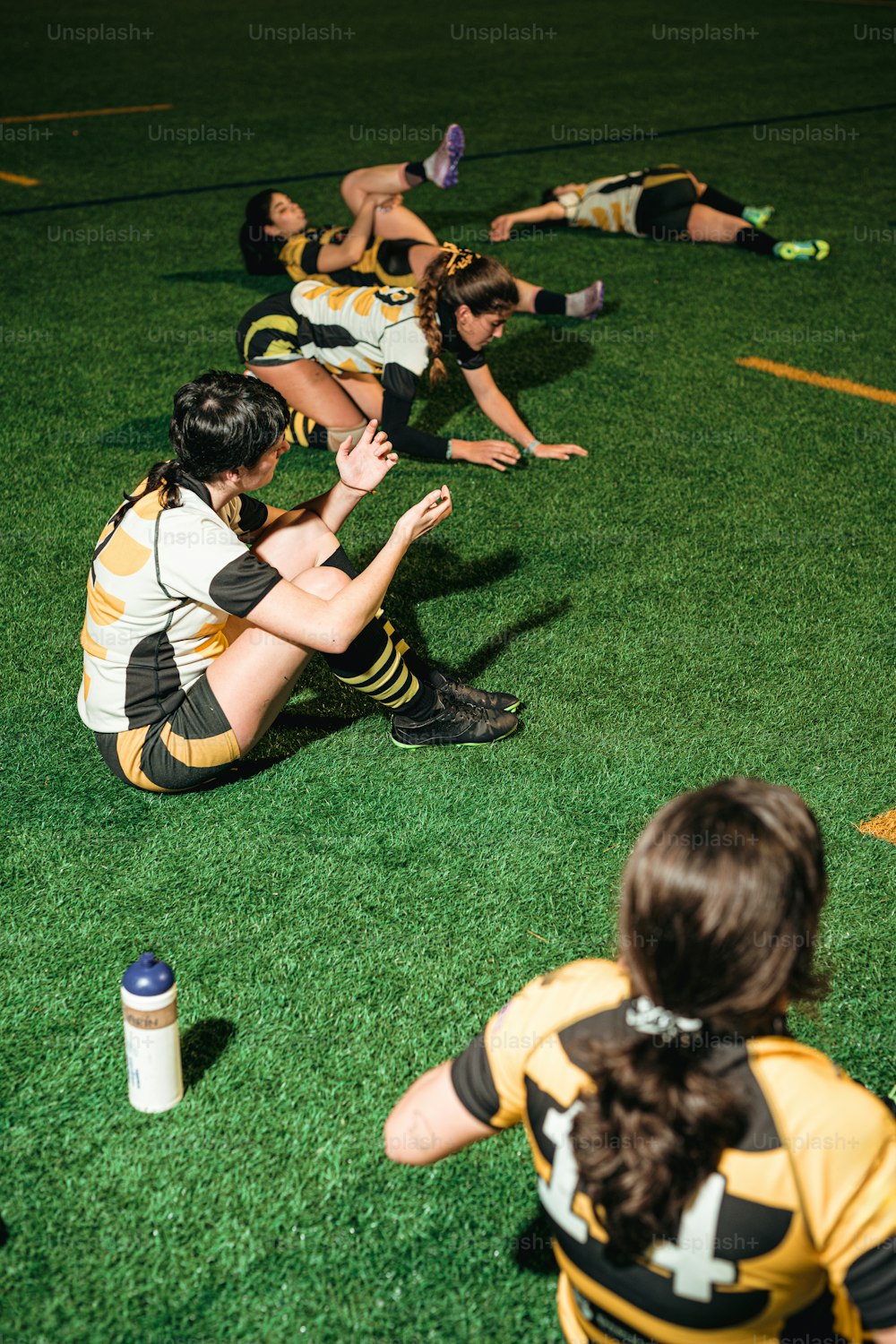Eine Gruppe von Frauen, die auf dem Boden sitzen und eine Partie Frisbee spielen