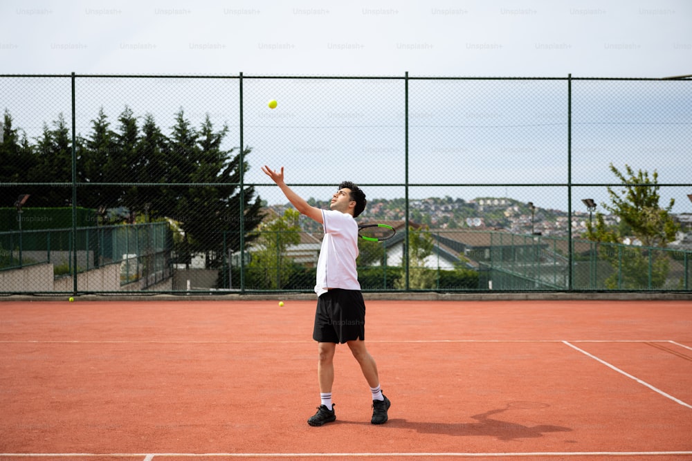 Ein Mann steht auf einem Tennisplatz und hält einen Schläger in der Hand