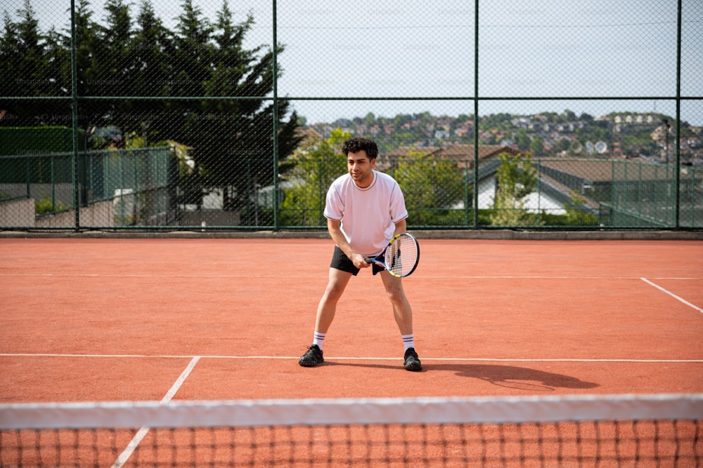 a man standing on a tennis court holding a racquet