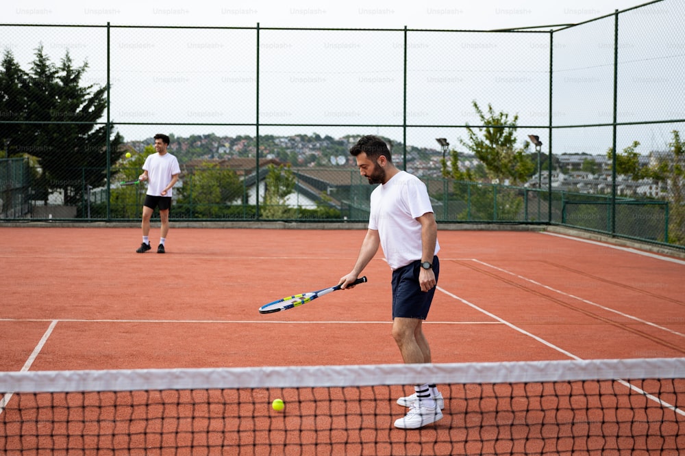 two men playing tennis on a tennis court