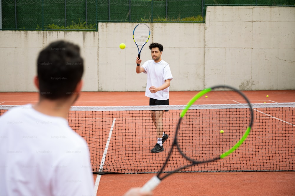 a man holding a tennis racquet on top of a tennis court