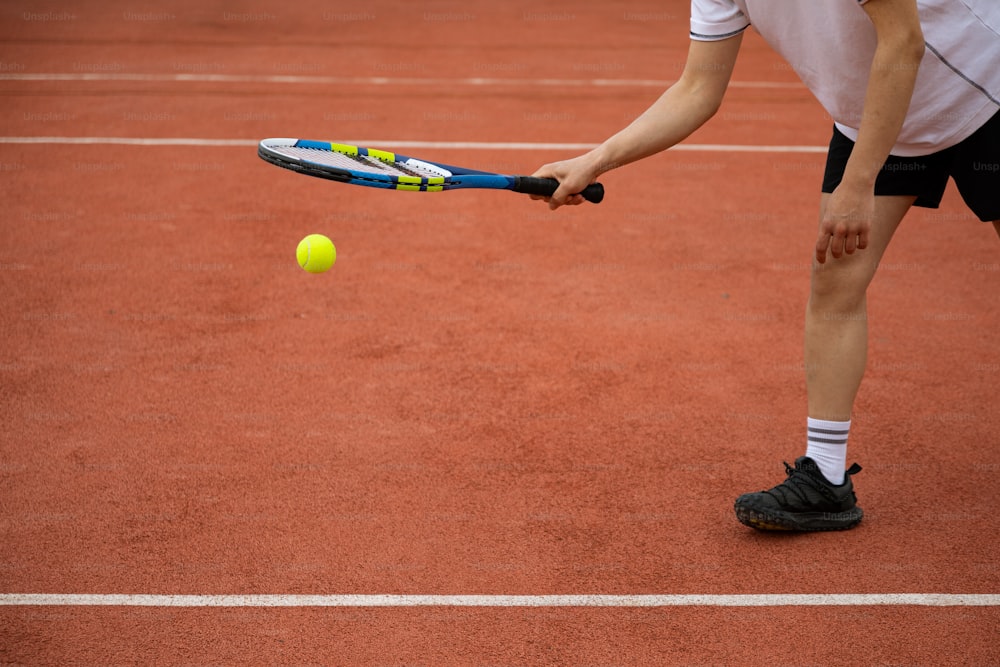 Ein Tennisspieler schlägt einen Tennisball mit einem Schläger