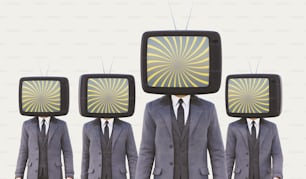 Un hombre de traje y corbata de pie frente a cuatro televisores