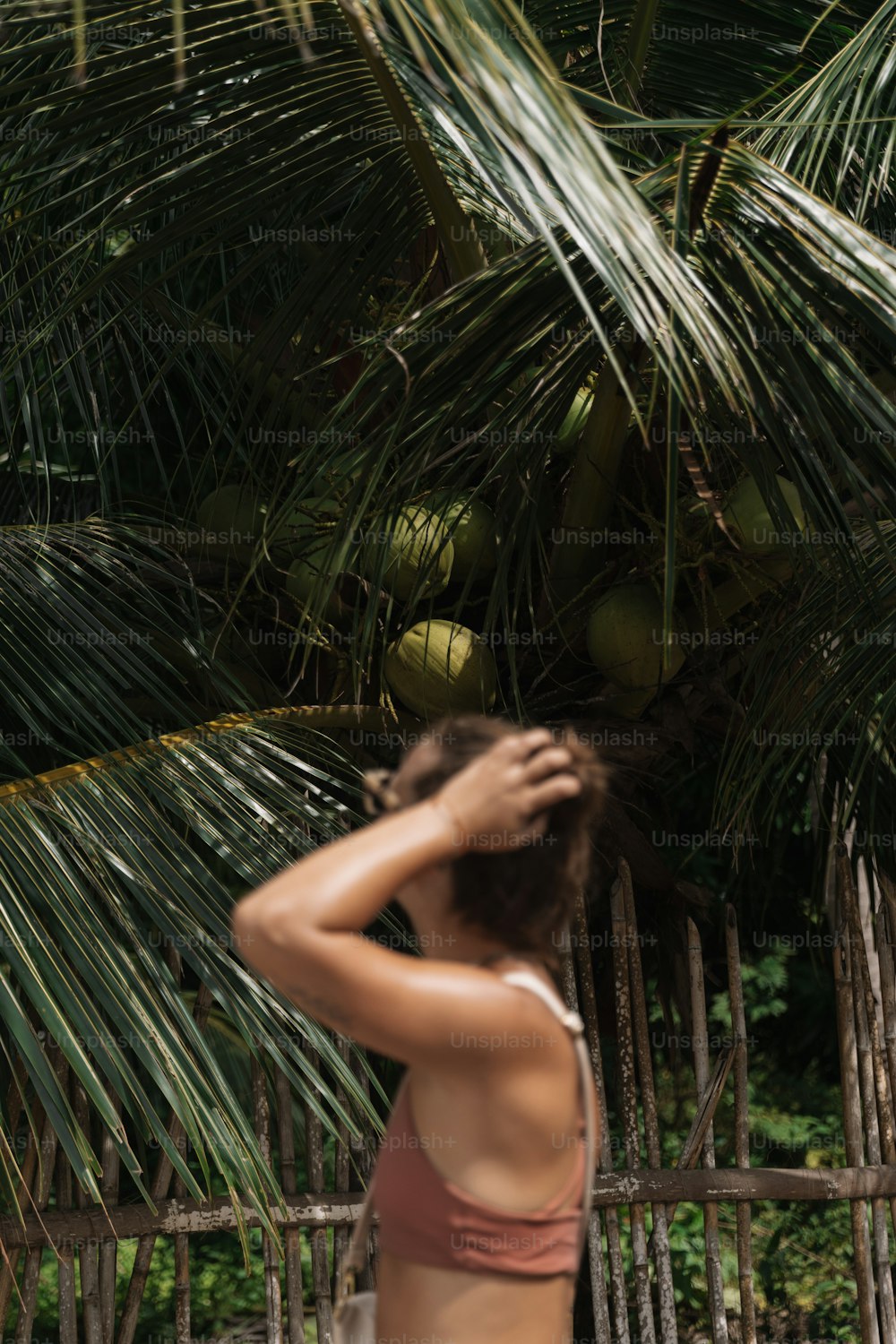 a woman standing in front of a palm tree