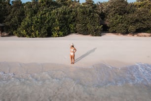 a woman standing in the sand on a beach