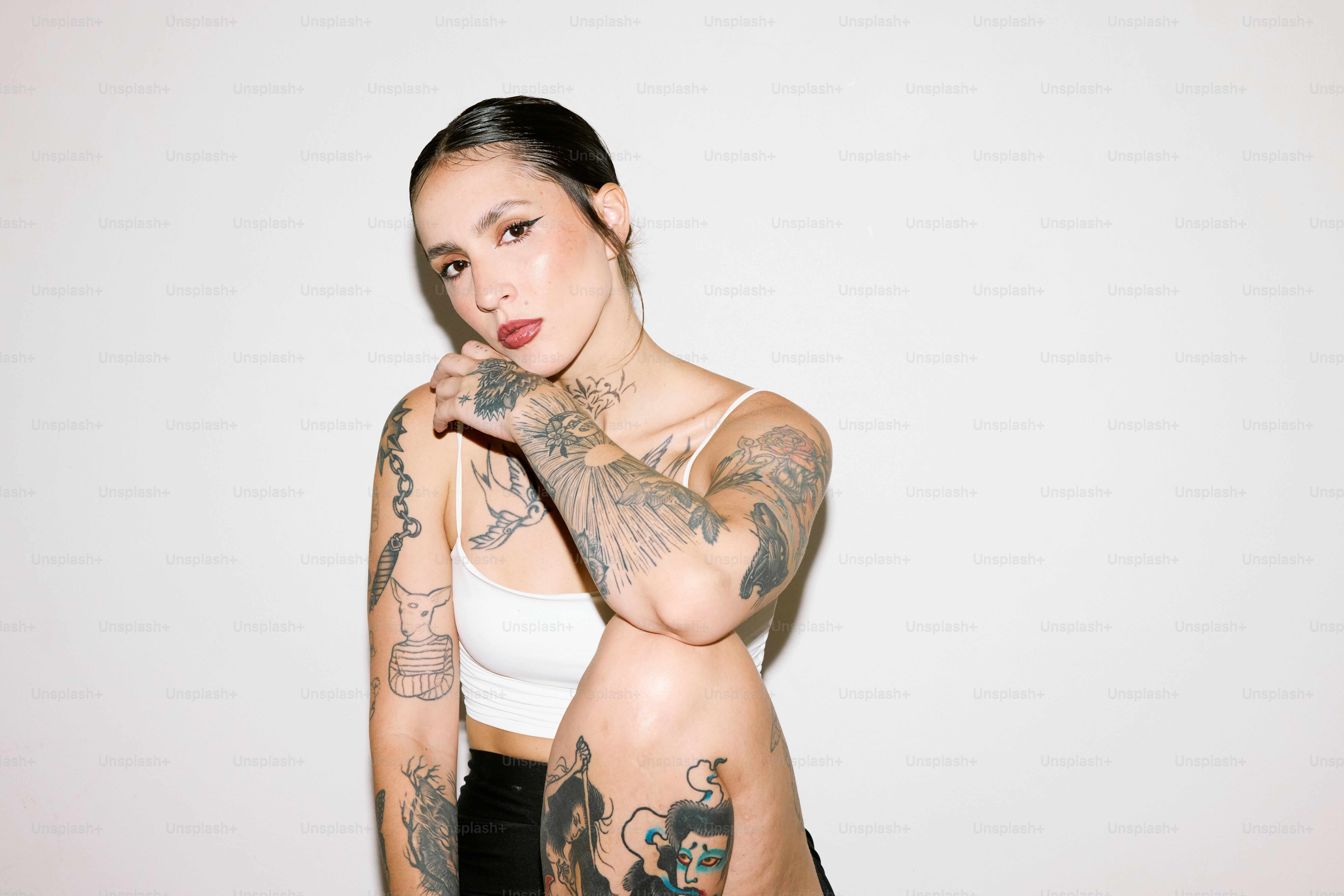 eine Frau mit Tattoos posiert für ein Foto