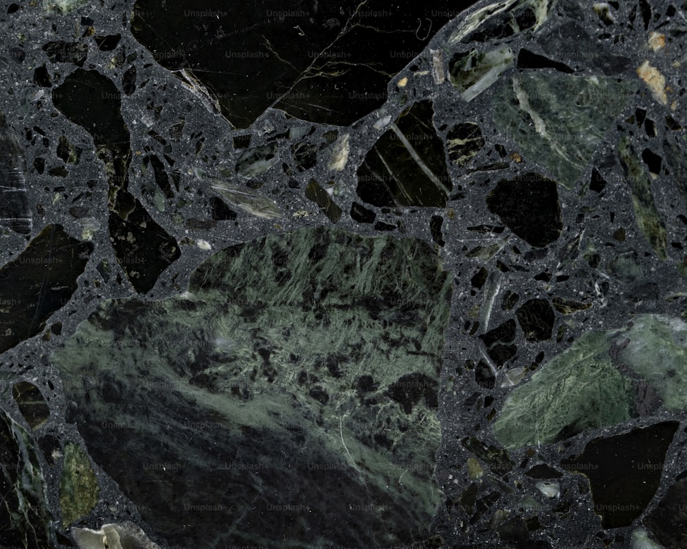 a close up of a black and green marble