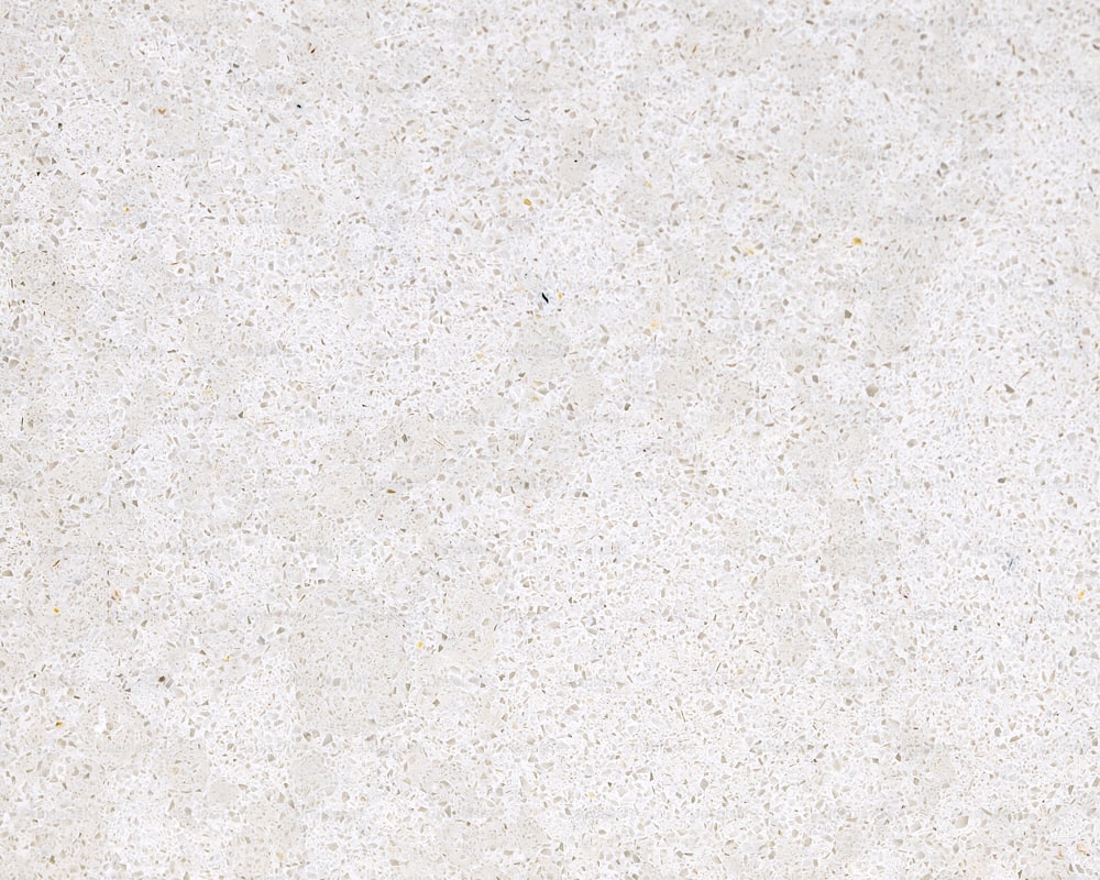 a close up of a white surface with small speckles