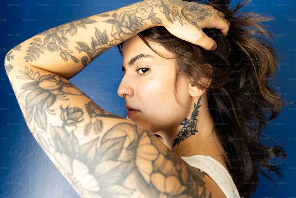 une femme avec des tatouages sur les bras et l’épaule