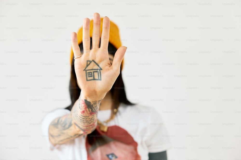 una donna con un tatuaggio della casa sulla mano