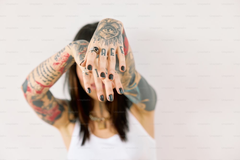 eine Frau mit Tätowierungen, die ihr Gesicht und ihre Hände bedecken
