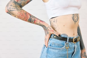 a woman with tattoos on her arms and stomach