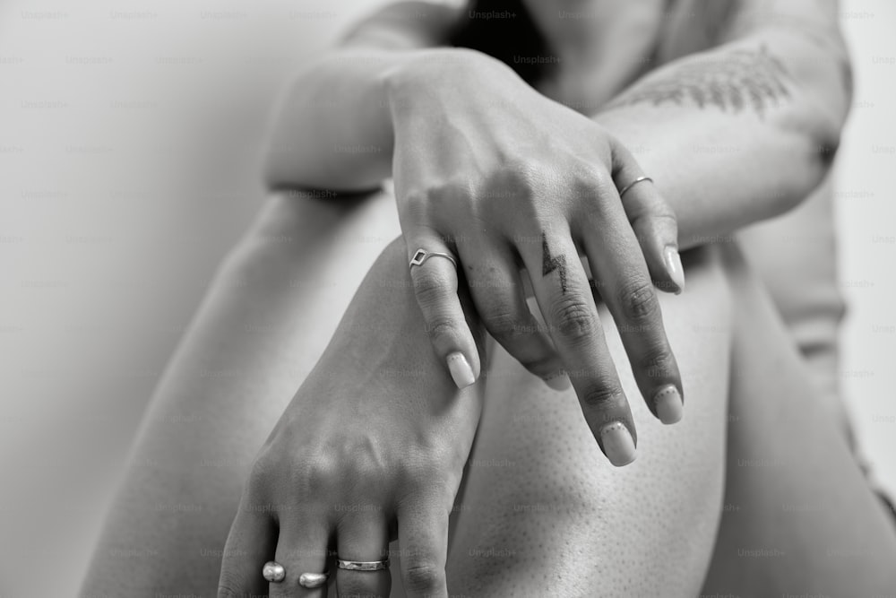 Una foto en blanco y negro de una mujer con tatuajes en el brazo