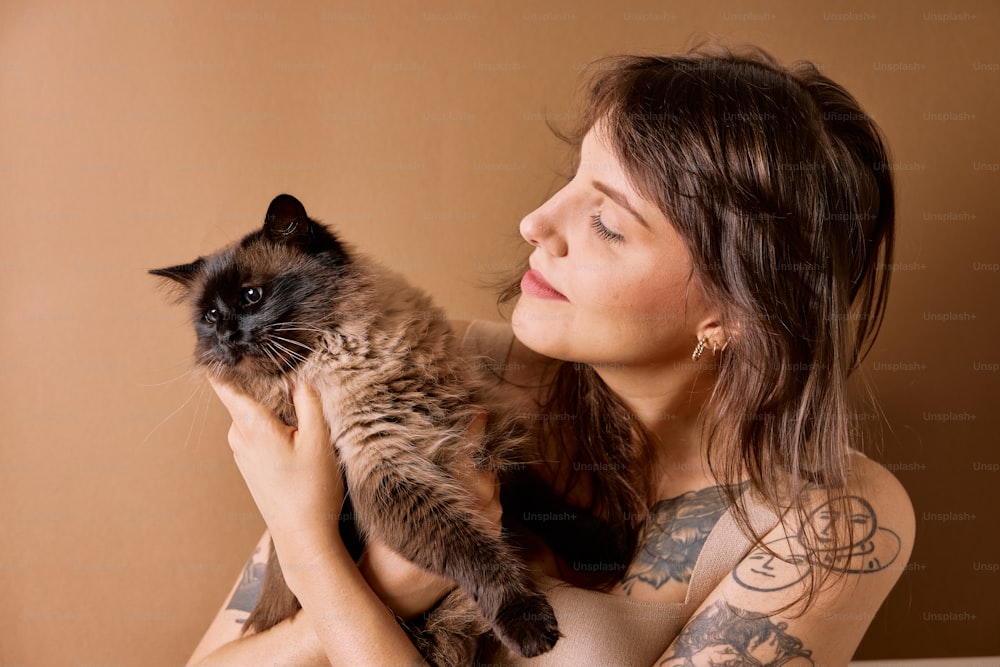 una donna che tiene un gatto tra le braccia