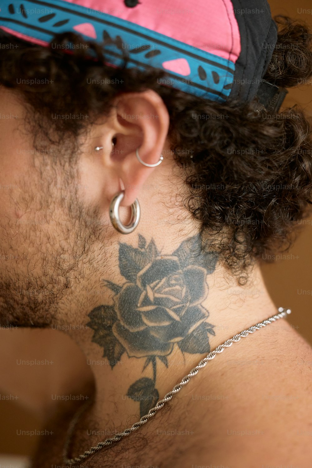 um homem com uma tatuagem de rosa no pescoço