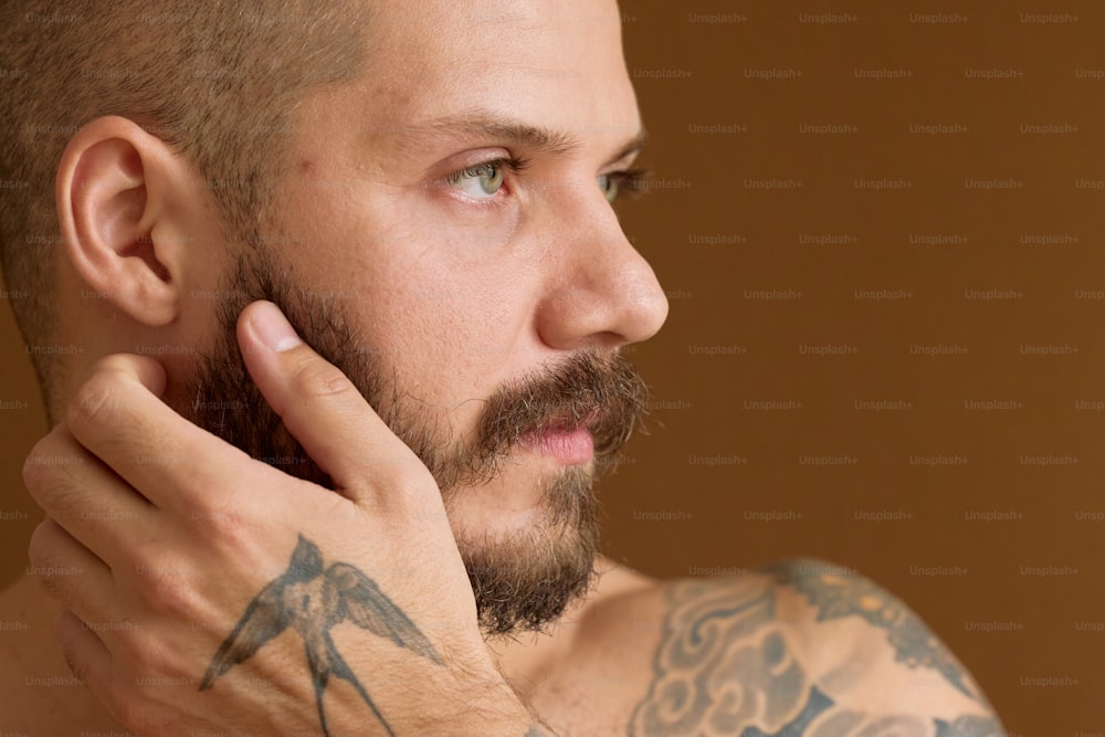 a man with a goatee and a tattoo on his arm