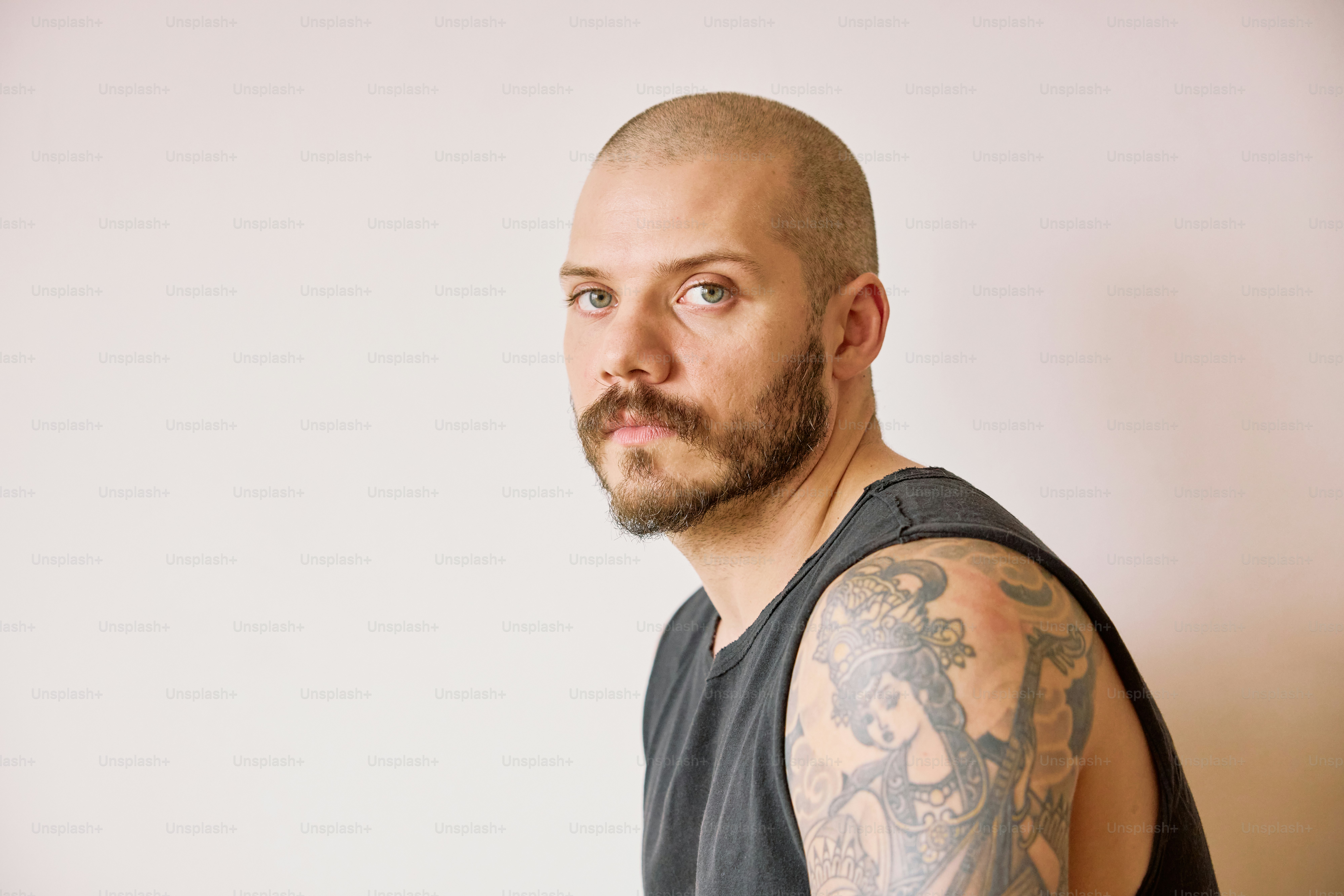 a man with a bald head wearing a tank top