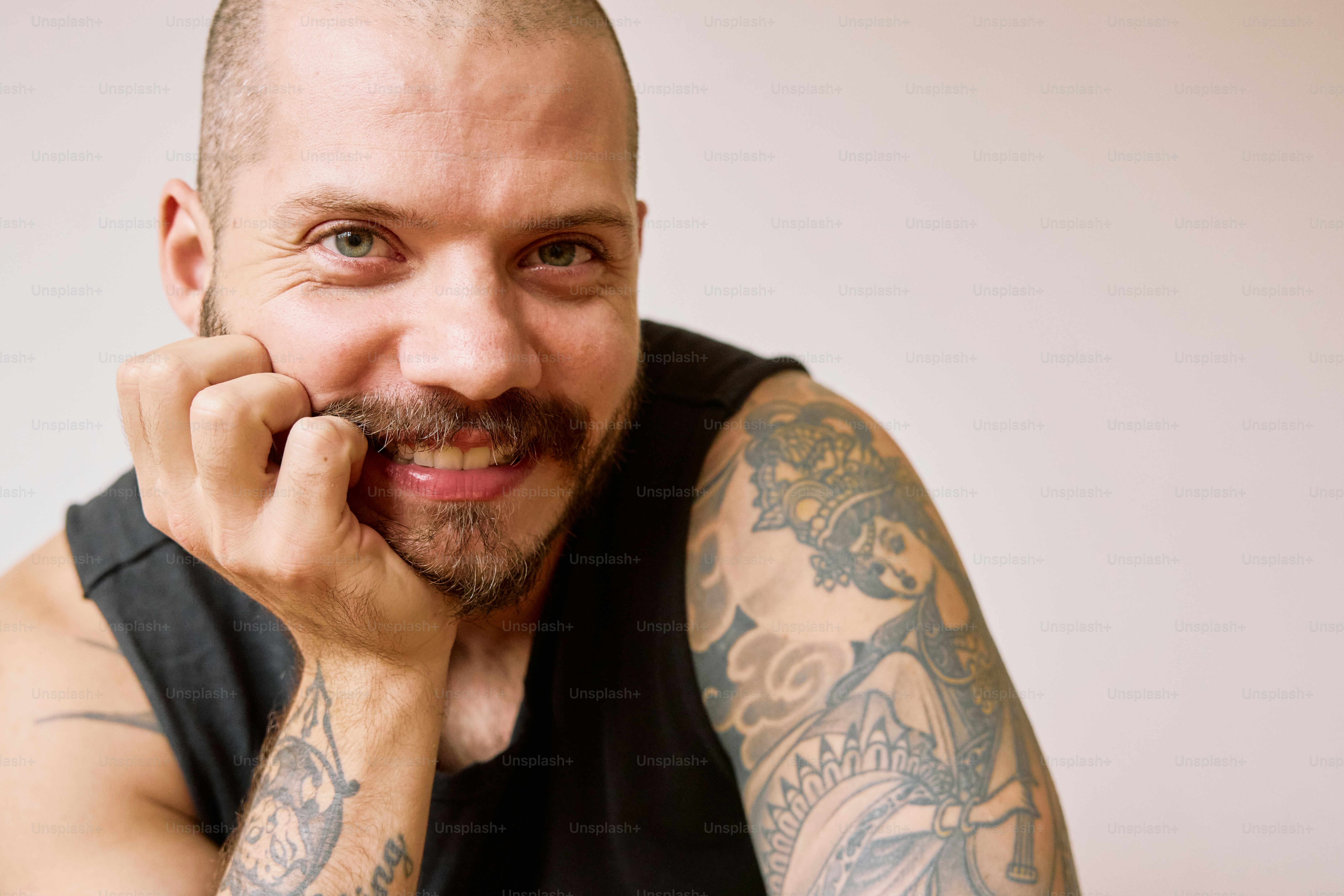 a man with a bald head and tattoos on his arms